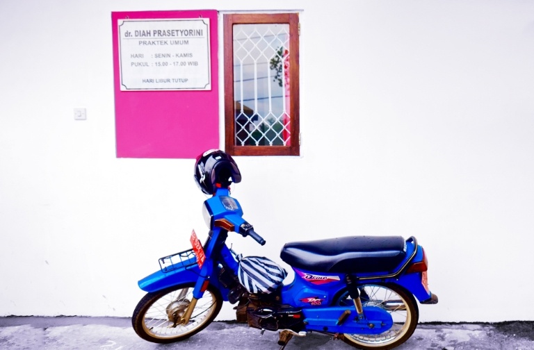 A motorbike, the favored form of transportation among Indonesian college students, sits outside a reproductive health clinic targeted at young people.
