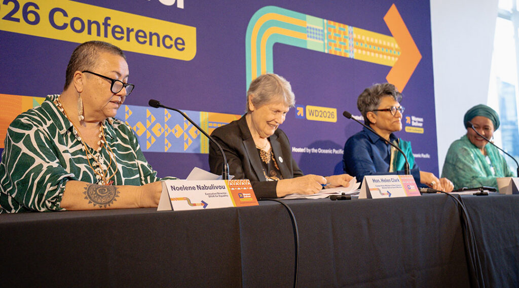 Noelene Nabulivou, Hon. Helen Clark, Dr. Maliha Khan, and Ms. Amina J. Mohammed sit behind microphones at a long table in front of a purple Women Deliver 2026 Conference backdrop.